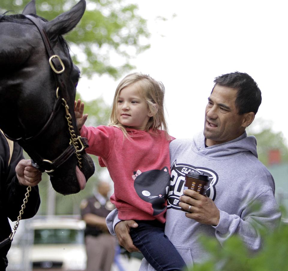 Jockey Corey Nakatani shows his daughter Lilha Kentucky Derby hopeful Dance With Fate after a morning workout at Churchill Downs Wednesday, April 30, 2014, in Louisville, Ky. (AP Photo/Garry Jones)