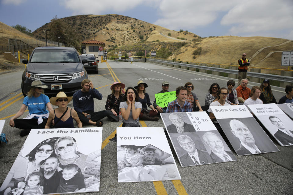 FILE - In this May 15, 2016 file photo people chant slogans during a protest outside the Aliso Canyon storage facility, in the Porter Ranch section of Los Angeles. Attorneys for families of the Aliso Canyon blowout, sickened and forced from their Los Angeles homes after the nation's largest-known natural gas leak, have reached a $1.8 billion settlement with a utility. The settlement announced Monday, Sept. 27, 2021, with Southern California Gas Co. and its parent company will compensate 35,000 plaintiffs from the 2015 blowout that took nearly four months to contain. (AP Photo/Jae C. Hong,File)