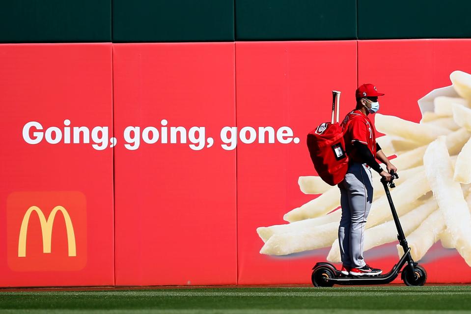 Cincinnati Reds third baseman Eugenio Suarez (7) rides an electric scooter around the warning track on his way out of the ballpark after the fourth inning of the MLB Cactus League Spring training game between the Cincinnati Reds and Cleveland at Goodyear Ballpark in Goodyear, Ariz., on  Sunday, Feb. 28, 2021.