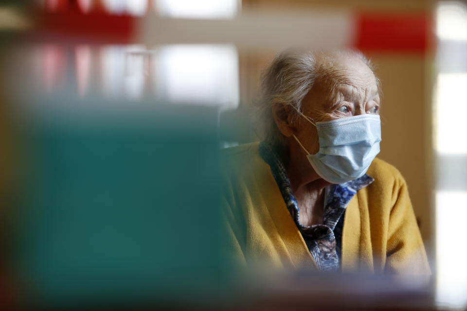 In this Tuesday April 21, 2020, photo, Marguerite Mouille, 94, looks away as her daughter visits her at the Kaisesberg nursing home, eastern France. France has started to break the seals on its locked down nursing homes, allowing limited visitation rights for the families of elderly residents. The visits are proving bittersweet for some, too short and restricted to make up for weeks of isolation and loneliness. But they are shedding light on the immense emotional toll caused by locking down care homes. (AP Photo/Jean-Francois Badias)