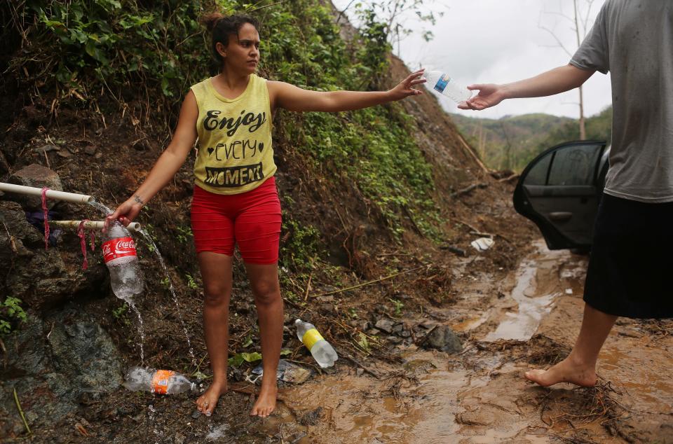 Yanira Rios collects spring water nearly three weeks after Hurricane Maria destroyed her town of Utuado. It's not clear if the water she's collecting is safe to drink. (Photo: Mario Tama via Getty Images)