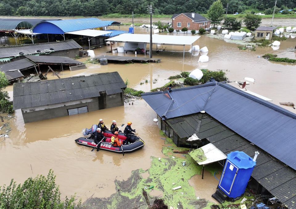 Rescue workers on a boat search for missing people in floodwaters caused by the tropical storm named Khanun in Daegu, South Korea, Thursday, Aug. 10, 2023. Khanun was pouring intense rain on South Korea on Thursday, turning roads into chocolate-colored rivers as it advanced north toward major urban centers near the capital. (Yun Kwan-shick/Yonhap via AP)