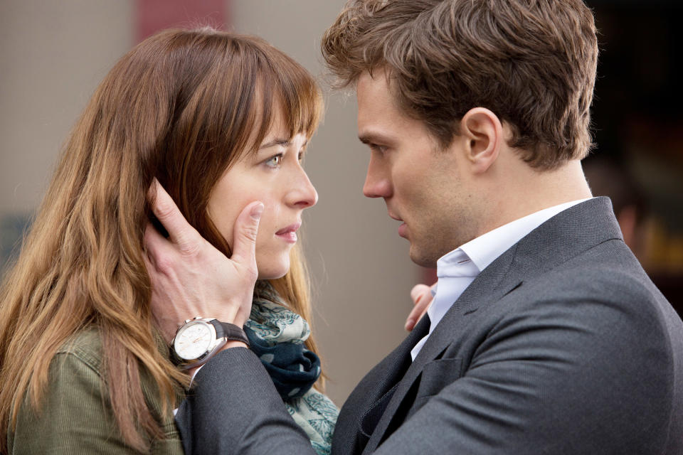 Dakota Johnson and Jamie Dornan stare at each other intensely in "Fifty Shades of Grey"