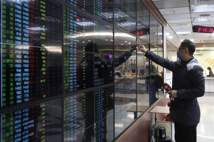 A man looks at an electronic stock board at Taipei Exchange in Taipei, Taiwan, Monday, Jan. 30, 2023. Shares were trading mixed in Asia on Monday after Wall Street benchmarks closed higher on Friday, capping a third week of gains out of the last four. (AP Photo/Chiang Ying-ying)