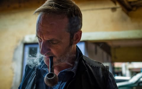 Wayne Hennessy-Barrett, smokes a pipe outside a 4G Capital offices in Wangige Town, Kiambu County, Kenya - Credit: Katie G. Nelson&nbsp;/The Telegraph