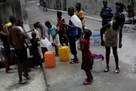 A girl cools off with drinkable water at a source in Port-au-Prince, Haiti, September 7, 2016. REUTERS/Andres Martinez Casares