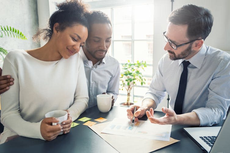 A young couple receives advice from a professional in an office