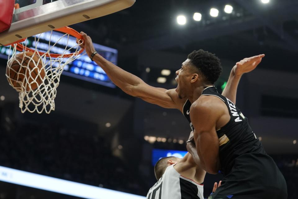 Milwaukee Bucks' Giannis Antetokounmpo dunks 0ver Los Angeles Clippers' Ivica Zubac during the second half of an NBA basketball game Friday, Dec. 6, 2019, in Milwaukee. (AP Photo/Morry Gash)