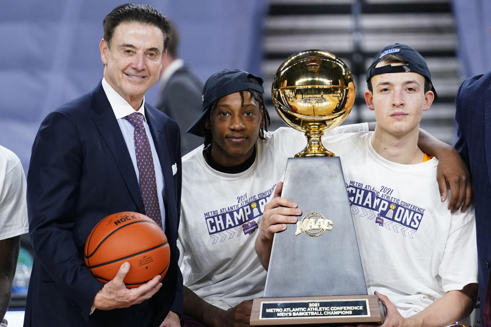 Iona head coach Rick Pitino, from left, Isaiah Ross and Dylan van Eyck pose with the trophy after winning an NCAA college basketball game against Fairfield during the finals of the Metro Atlantic Athletic Conference tournament, Saturday, March 13, 2021, in Atlantic City, N.J. (AP Photo/Matt Slocum)