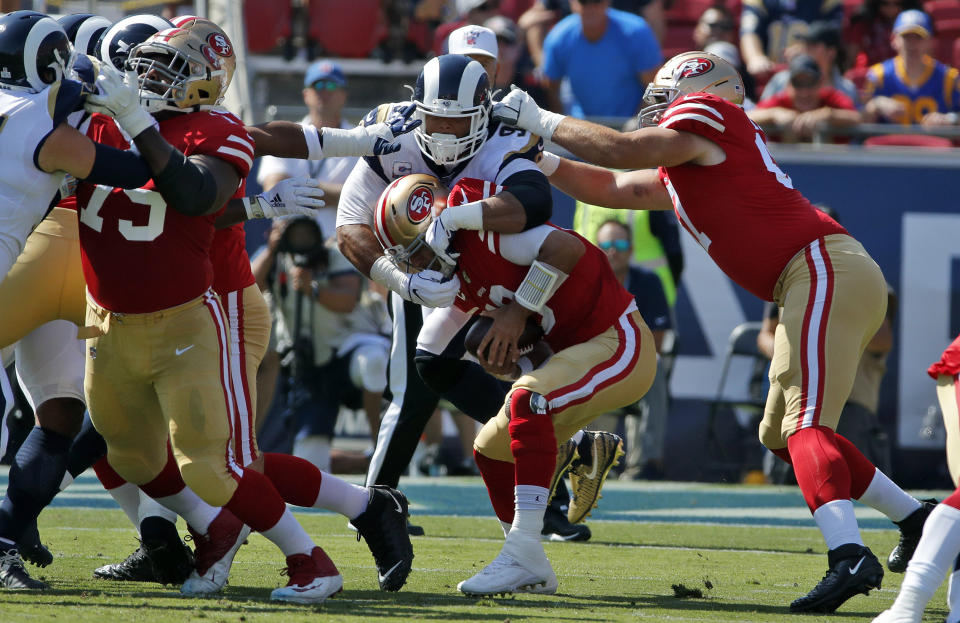 San Francisco 49ers quarterback Jimmy Garoppolo, bottom center, is sacked by -Los Angeles Rams defensive tackle Aaron Donald, top center, during the first half of an NFL football game Sunday, Oct. 13, 2019, in Los Angeles. (AP Photo/John Locher )