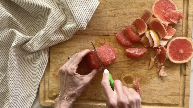 knife cutting grapefruit segments