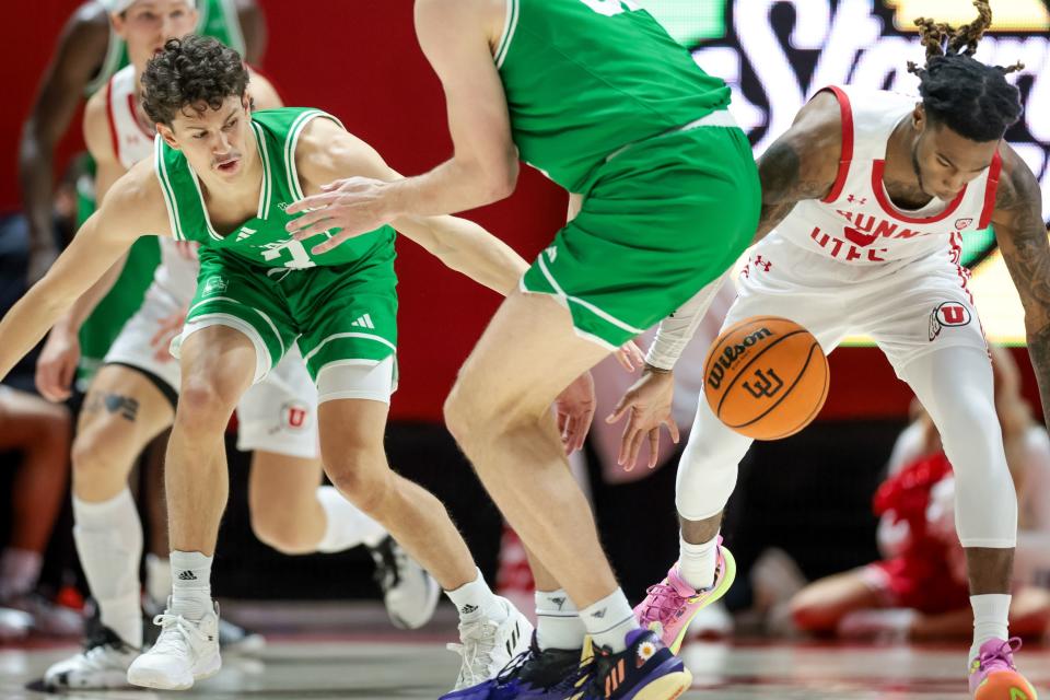 Utah Utes guard Deivon Smith (wearing white) strips the ball from Utah Valley Wolverines guard Drake Allen.