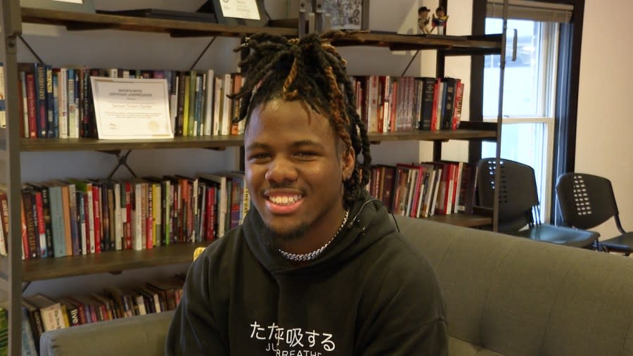 Student in a library smiling.