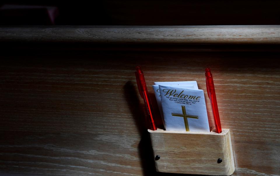 Tithe envelops sit in the pews during a Palm Sunday service at First United Methodist Church in Parsons, Tenn., Sunday, April 10, 2022.