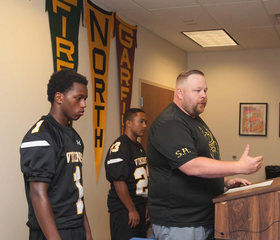 North head football coach Doug Miller, right, speaks during the Akron Public Schools Football Media Day as he stands with players Zi'Velle Thomas, left, and Elijah Gervins. The team ended up suspending its season with two games left due to a lack of available players.