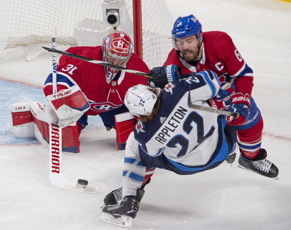 Montreal Canadiens' Shea Weber (6) knocks down Winnipeg Jets' Mason Appleton (22) in front of Canadiens goalie Carey Price (31) during the third period of an NHL Stanley Cup playoff hockey game in Montreal, Sunday, June 6, 2021. (Paul Chiasson/The Canadian Press via AP)
