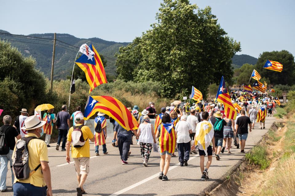 Pro-independence Catalan demonstrators march towards Vimbodi, northeastern Spain, Monday, July 20, 2020 during a protest against the visit of Spain's King Felipe VI and Queen Letizia. The royal visit comes as a barrage of media leaks have revealed how the king's father, former monarch Juan Carlos I, allegedly hid millions of untaxed euros in offshore funds. (Marc Brugat/Europa Press via AP)