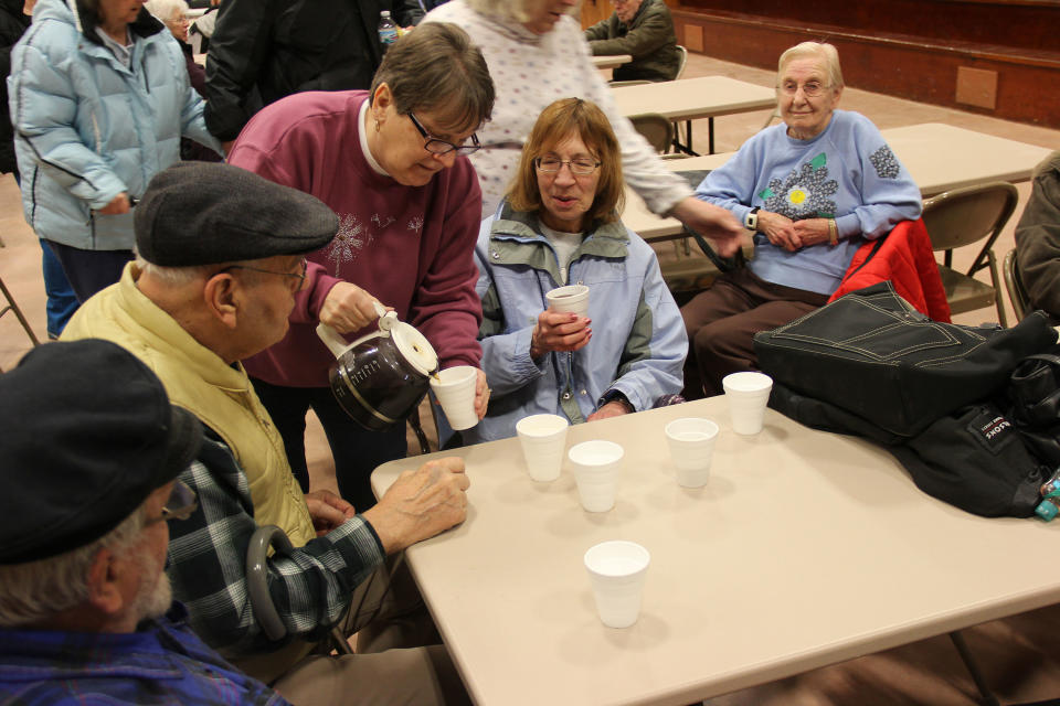 Jane Ritzert of Kensett, Iowa, pours coffee for evacuees at the at the Kensett Community Center, a former school gymnasium, in Northwood, Iowa, Thursday, Feb. 20, 2014, after a chemical fire at a fertilizer plant forced the evacuation of the town. Sulfuric acid for fertilizer is on fire at a storage facility at the Northwood airport. Northwood has a population of about 2,000 people. (AP Photo/Albert Lea Tribune, Tim Engstrom)