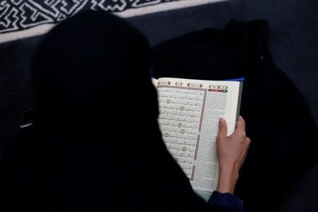 A woman reads Koran at a mosque in Jakarta, Indonesia, June 7, 2018. Picture taken June 7, 2018. REUTERS/Beawiharta