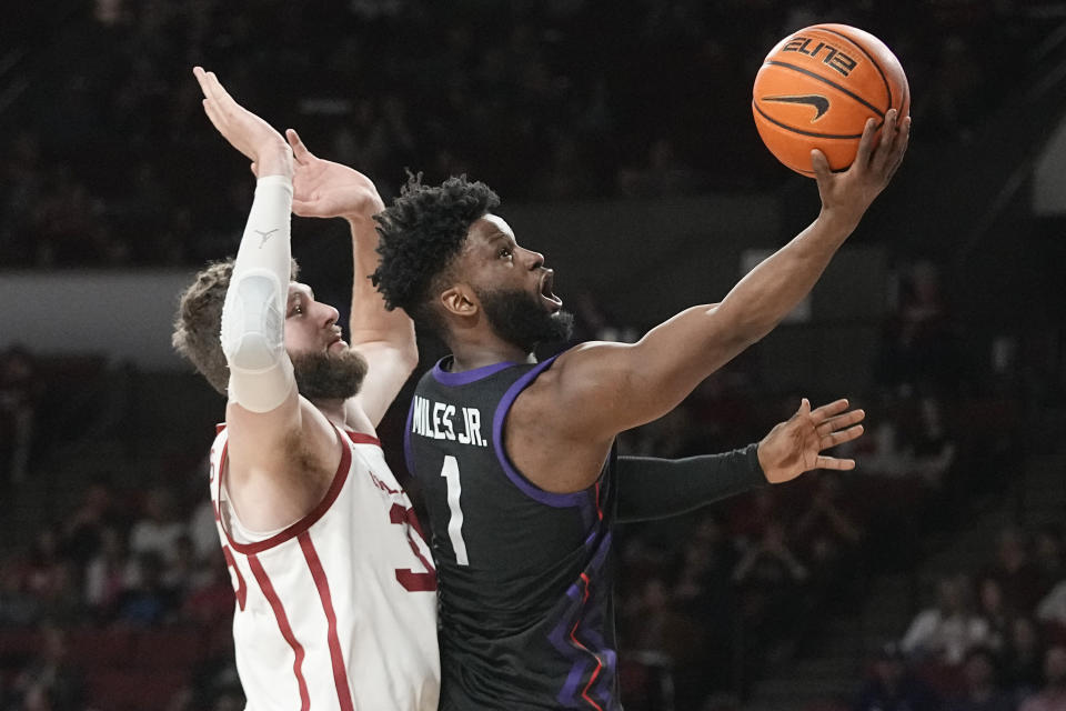 TCU guard Mike Miles Jr. (1) shoots in front of Oklahoma forward Tanner Groves, left, in the first half of an NCAA college basketball game Saturday, March 4, 2023, in Norman, Okla. (AP Photo/Sue Ogrocki)