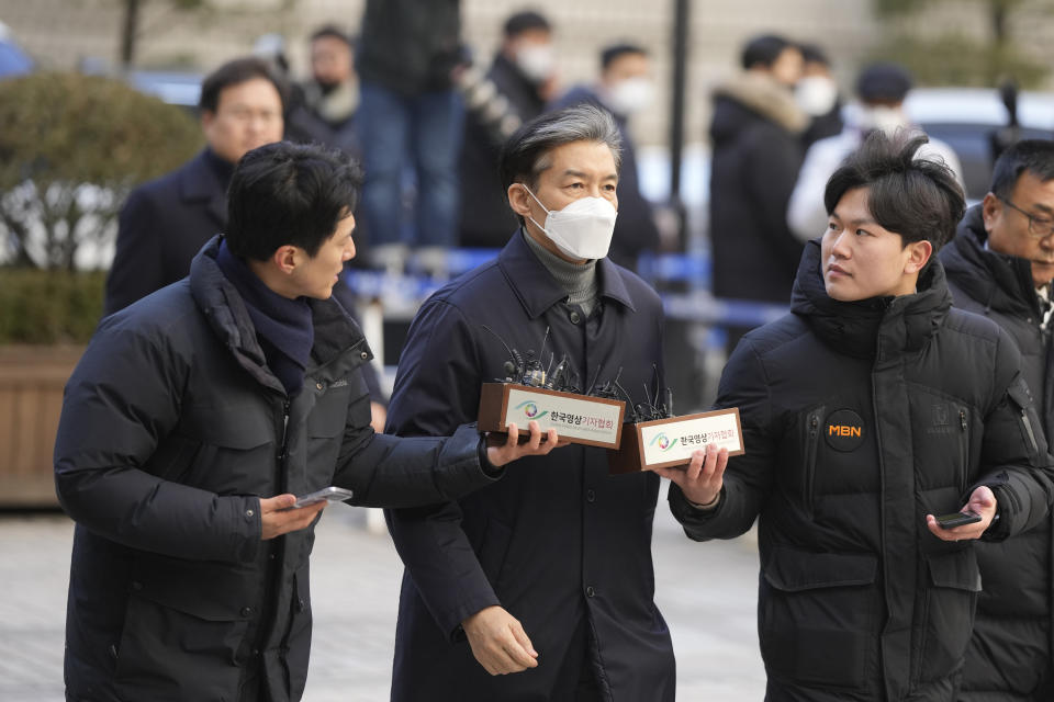 Former Justice Minister Cho Kuk, center, is questioned by reporters upon his arrival at the Seoul Central District Court in Seoul, South Korea, Friday, Feb. 3, 2023. The court on Friday sentenced Cho to two years in prison, after he was found guilty of creating fake credentials to help his children get into prestigious schools, a scandal that rocked the country’s previous government and sparked huge protests. (AP Photo/Lee Jin-man)