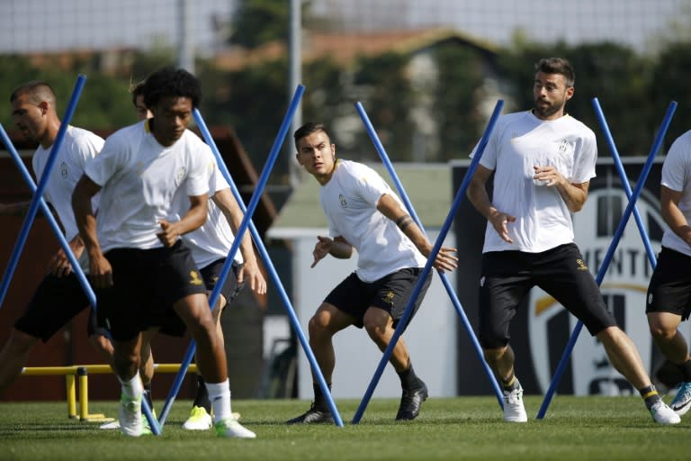 Juventus forward Paulo Dybala (C) and defender Andrea Barzagli (R) take part in a training session in Vinovo, near Turin on April 10, 2017, the eve of the Champions League match against Barcelona