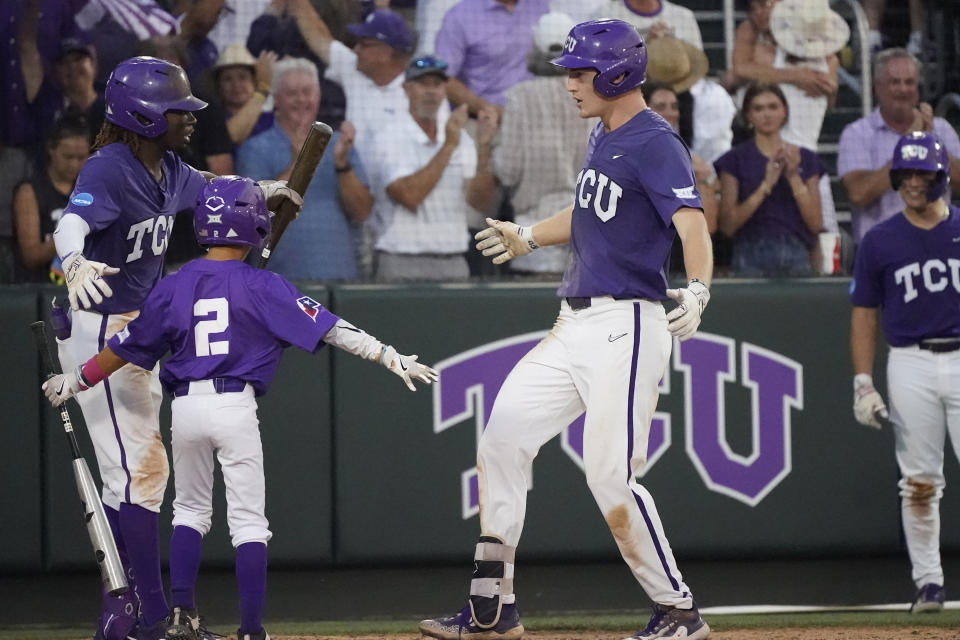 TCU's Cole Fontenelle, right, crosses home plate after his solo homer during the fifth inning of an NCAA college baseball super regional game against Indiana State in Fort Worth, Texas, Saturday, June 10, 2023. (AP Photo/LM Otero)