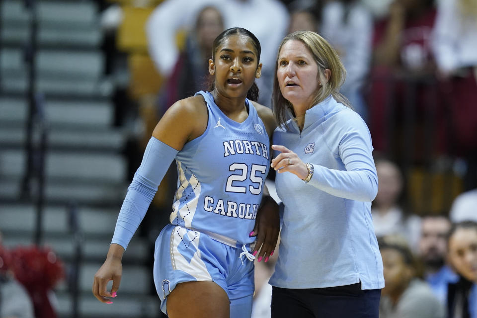 FILE - North Carolina coach Courtney Banghart talks with Deja Kelly during the first half of the team's NCAA college basketball game against Indiana, Thursday, Dec. 1, 2022, in Bloomington, Ind. Women's college basketball has typically kept players around compared to the frequent early exits to the professional ranks that are so common on the men's side. But the women's game has gotten even older with players having extra eligibility from the COVID-19 pandemic. That has first-year players facing more fifth- and sixth-year players, creating a bigger gap to overcome in experience and strength than before. (AP Photo/Darron Cummings, File)