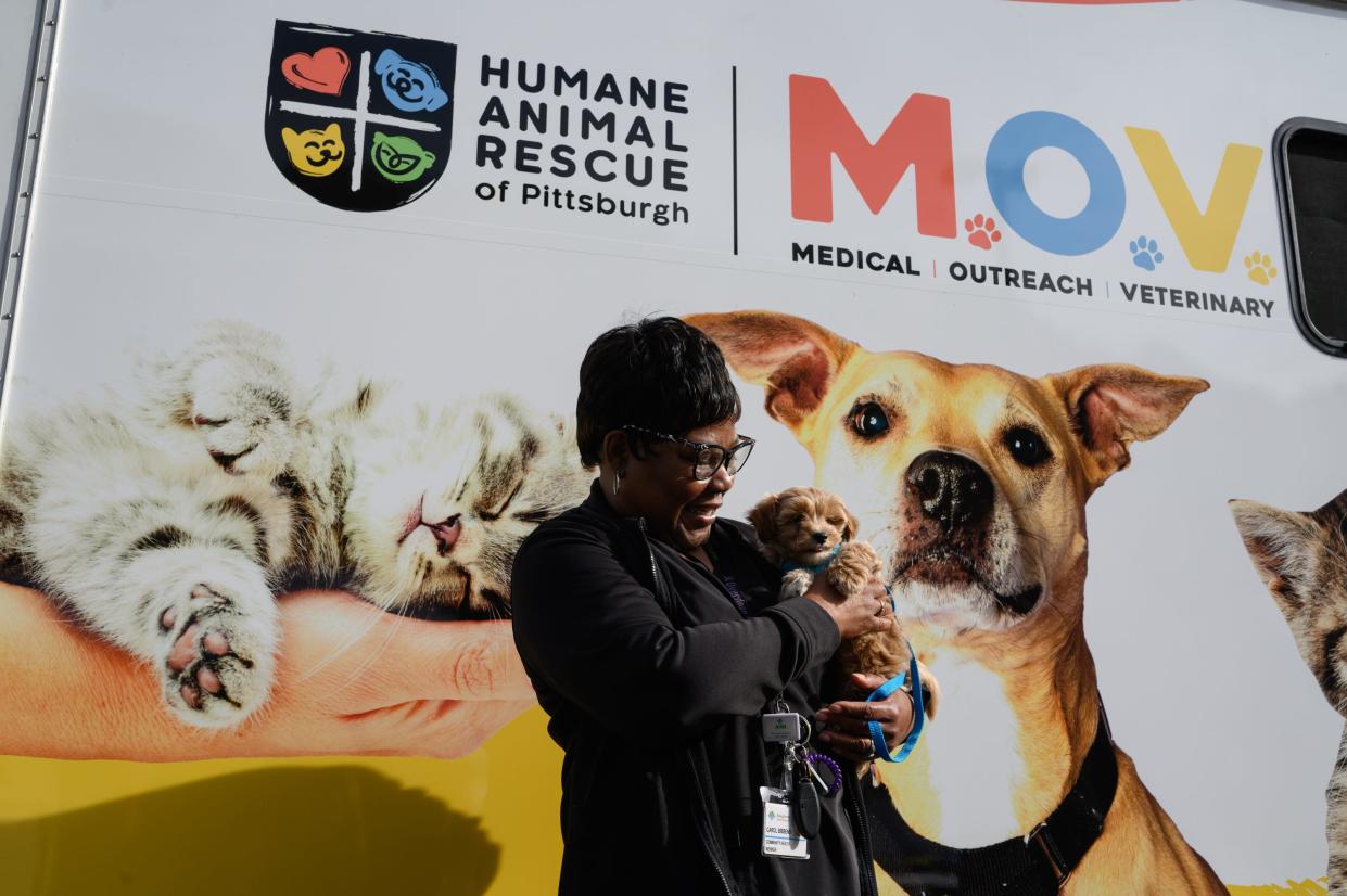 Carol Bobbins, 61, a community health worker holds her dog, Louis, at a mobile clinic for pets and their owners on Oct. 26 in Pittsburgh.