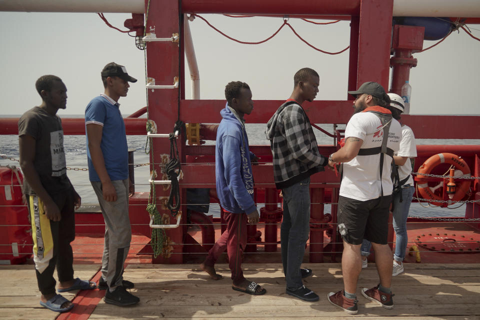 Men wait to be registered by Doctors Without Borders on the Ocean Viking in the Mediterranean Sea, Tuesday, Sept. 17, 2019. The humanitarian rescue ship pulled 48 people from a small and overcrowded wooden boat including a newborn and a pregnant woman. (AP Photo/Renata Brito)