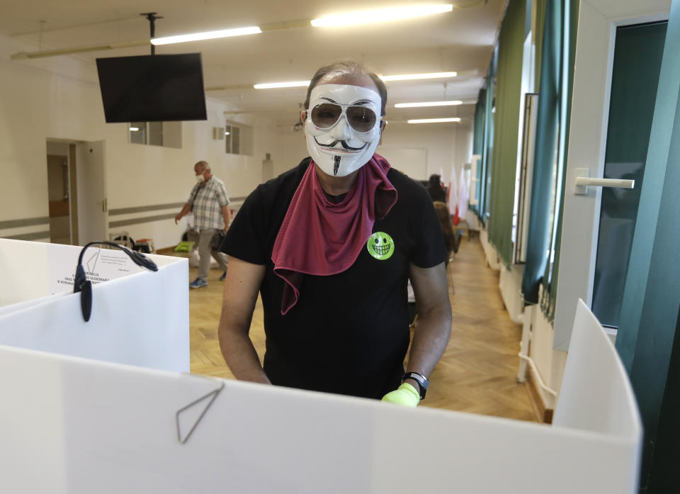 A man, wearing a face mask, prepares to cast his vote during presidential election in Warsaw, Poland, Sunday, June 28, 2020. The election will test the popularity of incumbent President Andrzej Duda who is seeking a second term and of the conservative ruling party that backs him. (AP Photo/Petr David Josek)