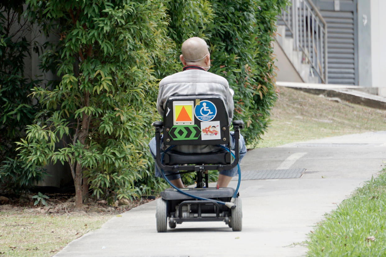 An elderly user of a personal mobility aid (PMA) in Singapore. 