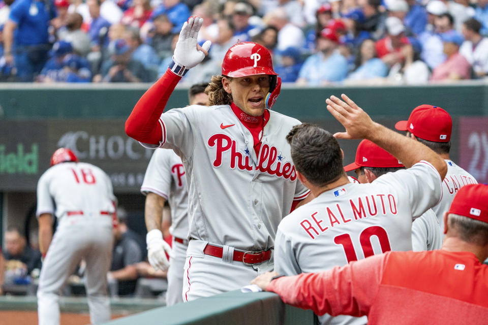 Philadelphia Phillies' Alec Bohm is congratulated in the dugout after hitting a two-run home run that scored Nick Castellanos during the second inning of an opening day baseball game, Thursday, March 30, 2023, in Arlington, Texas. (AP Photo/Jeffrey McWhorter)