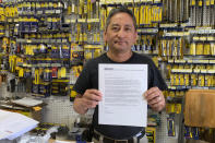 In this photo taken Wednesday, Aug. 28, 2019, Albert Chow, owner of Great Wall Hardware in San Francisco, holds a May 2019 letter from a supplier notifying him that prices will be increasing 10 to 18 percent because of US tariffs on Chinese goods. He says he has no choice but to raise store prices on those products. (AP Photo/Terry Chea)