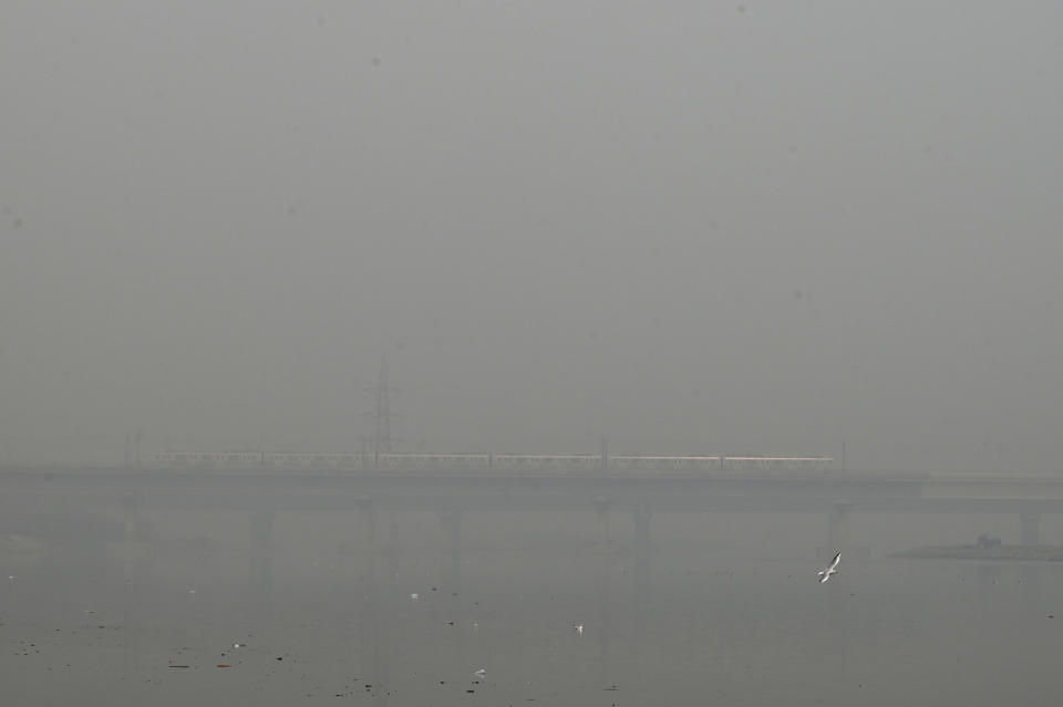 A metro train runs on a bridge enveloped by smog and haze in New Delhi, India, Friday, Nov. 4, 2022.Indian authorities on Friday shut polluting industries and construction activity, restricted diesel-run vehicles and deployed water sprinklers and anti-smog guns to control haze and smog enveloping the skyline of the Indian capital region. (AP Photo)