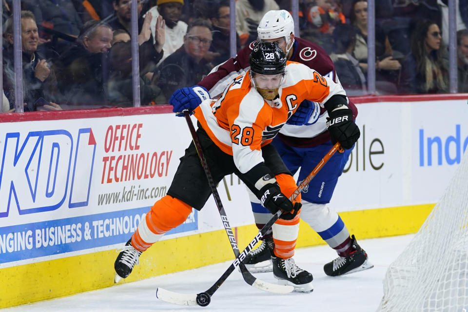 Philadelphia Flyers' Claude Giroux, left, and Colorado Avalanche's Devon Toews battle for the puck during the second period of an NHL hockey game, Monday, Dec. 6, 2021, in Philadelphia. (AP Photo/Matt Slocum)