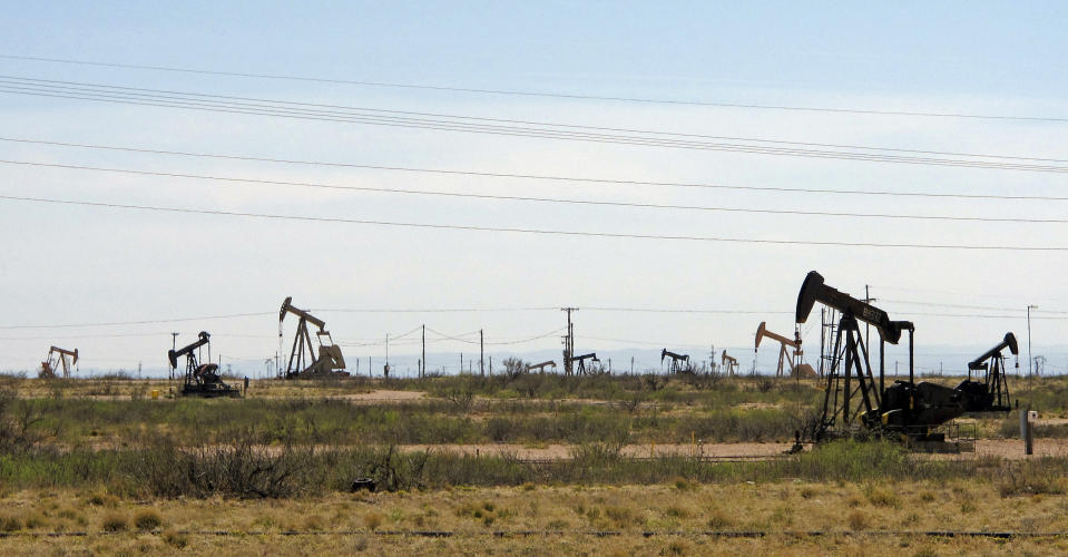 FILE - In this April 9, 2014, file photo, oil rigs stand in the Loco Hills field on U.S. Highway 82 in Eddy County near Artesia, N.M., one of the most active regions of the Permian Basin. In the closing months of the Trump administration energy companies stockpiled enough drilling permits for western public lands to keep pumping oil for years. That stands to undercut President-elect Joe Biden's plans to block new drilling on public lands to address climate change. (AP Photo/Jeri Clausing, File)