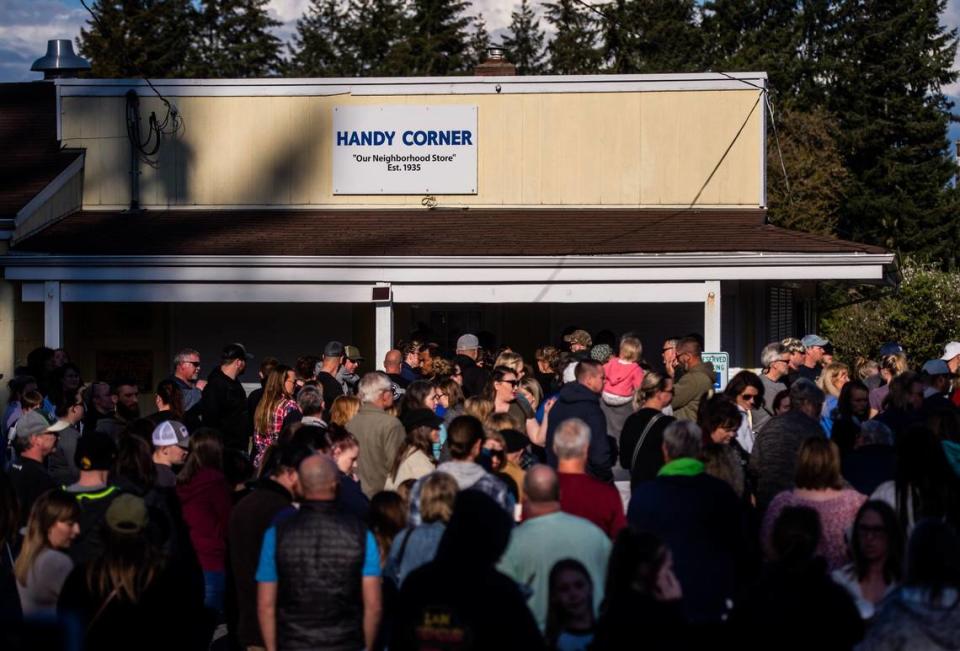 People gather for a candlelight vigil for Soon Ja Nam, 79, who owned the Handy Corner Store in Puyallup, Wash., on Sunday, April 28, 2019. Nam was shot and killed during a robbery.