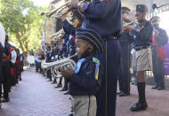 A young trumpeter joins a band for the arrival of the hearse, carrying the coffin of Anglican Archbishop Emeritus Desmond Tutu at the St. George's Cathedral Friday, Dec. 31, 2021 where he will lie in state for a second day in Cape Town, South Africa. Tutu, the Nobel Peace Prize-winning activist for racial equality and LGBT rights died Sunday at the age of 90. (AP Photo/Tsvangirayi Mukwazhi)