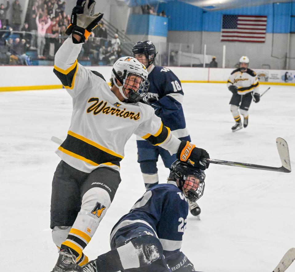 Sam Mayhew of Nauset stumbles over Soaren Edwardes of Nantucket in celebration after putting in the fifth goal in what would be a 6-2 victory.