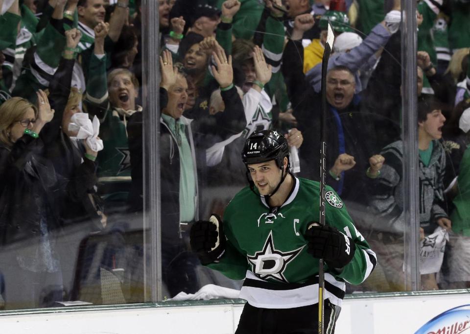 Fans celebrate along with Dallas Stars left wing Jamie Benn (14) after a score by Benn in the first period of Game 3 of a first-round NHL hockey Stanley Cup playoff series game, Monday, April 21, 2014, in Dallas. (AP Photo/Tony Gutierrez)