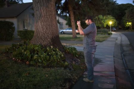 Water conservation official Steven Upton photographs a home that has evidence of watering on a mandatory "no watering" day, in this August 15, 2014 file photo taken in Sacramento, California. REUTERS/Max Whittaker/Files