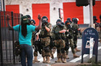 <p>Police force protestors from the business district into nearby neighborhoods on August 11, 2014 in Ferguson, Missouri. Police responded with tear gas and rubber bullets as residents and their supporters protested the shooting by police of an unarmed black teenager named Michael Brown who was killed Saturday in this suburban St. Louis community. Yesterday 32 arrests were made after protests turned into rioting and looting in Ferguson. (Scott Olson/Getty Images) </p>