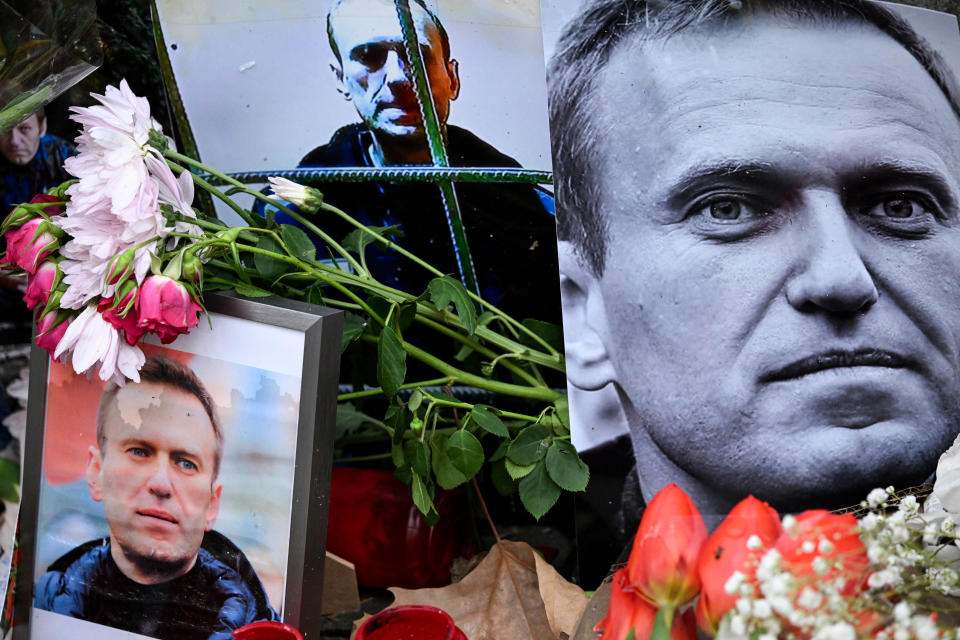 Flowers are seen placed around portraits of Alexei Navalny at a makeshift memorial in front of the former Russian consulate in Frankfurt.
