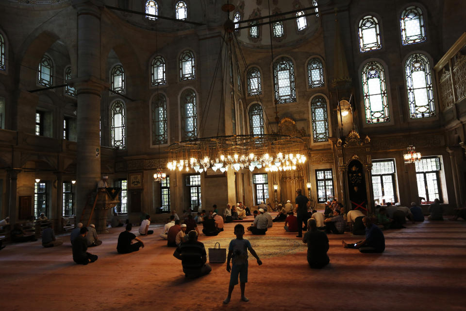 People sit in a mosque in Istanbul, Wednesday, Aug. 15, 2018. The Turkish lira currency has nosedived in value in the past week over concerns about Turkey's President Recep Tayyip Erdogan's economic policies and after the United States slapped sanctions on Turkey angered by the continued detention of an American pastor. (AP Photo/Lefteris Pitarakis)