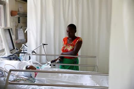 FILE PHOTO: Lenzer, mother of six month-old Samantha Pendo, stands next to her bed as the girl remains in critical condition in the Intensive Care Unit of Aga Khan Hospital in Kisumu, Kenya August 14, 2017. REUTERS/Baz Ratner/File Photo