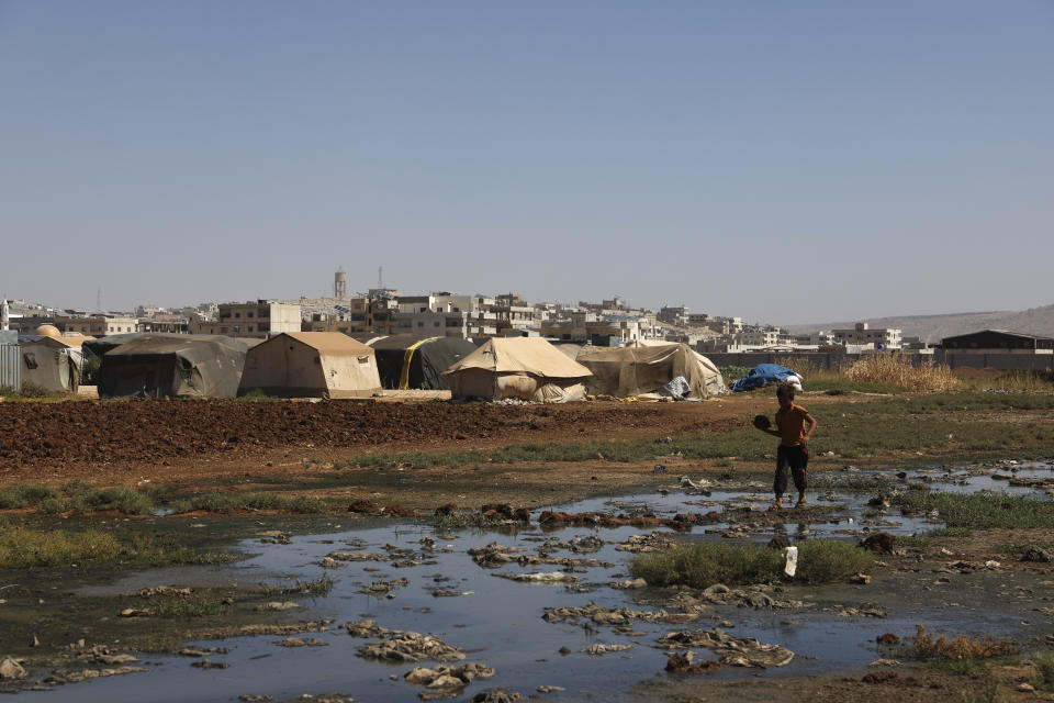 A Syrian child walks in a stream of open sewage in the Salaheddine camp in northwestern Syria on Wednesday, Sept. 28, 2022. In recent weeks, thousands of cholera cases have swept across the crisis-stricken countries of Lebanon, Syria, and Iraq. (AP Photo/Ghaith Alsayed)