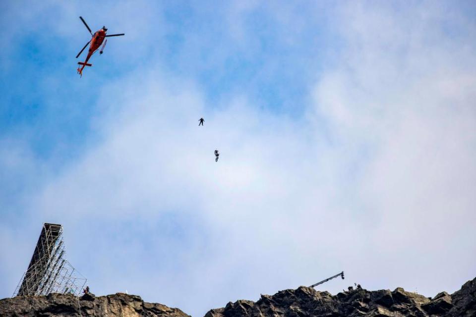 Tom Cruise (dot in centre) rides a motorbike off a ramp at the top of a Norwegian cliff last September, while filming the next Mission Impossible movie.