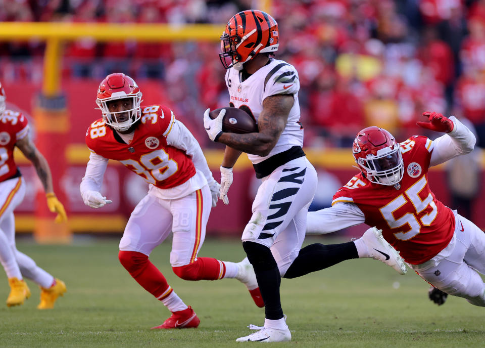 KANSAS CITY, MISSOURI - JANUARY 30: Running back Joe Mixon #28 of the Cincinnati Bengals eludes the tackle of defensive end Frank Clark #55 of the Kansas City Chiefs during the first half of the AFC Championship Game at Arrowhead Stadium on January 30, 2022 in Kansas City, Missouri. (Photo by David Eulitt/Getty Images)