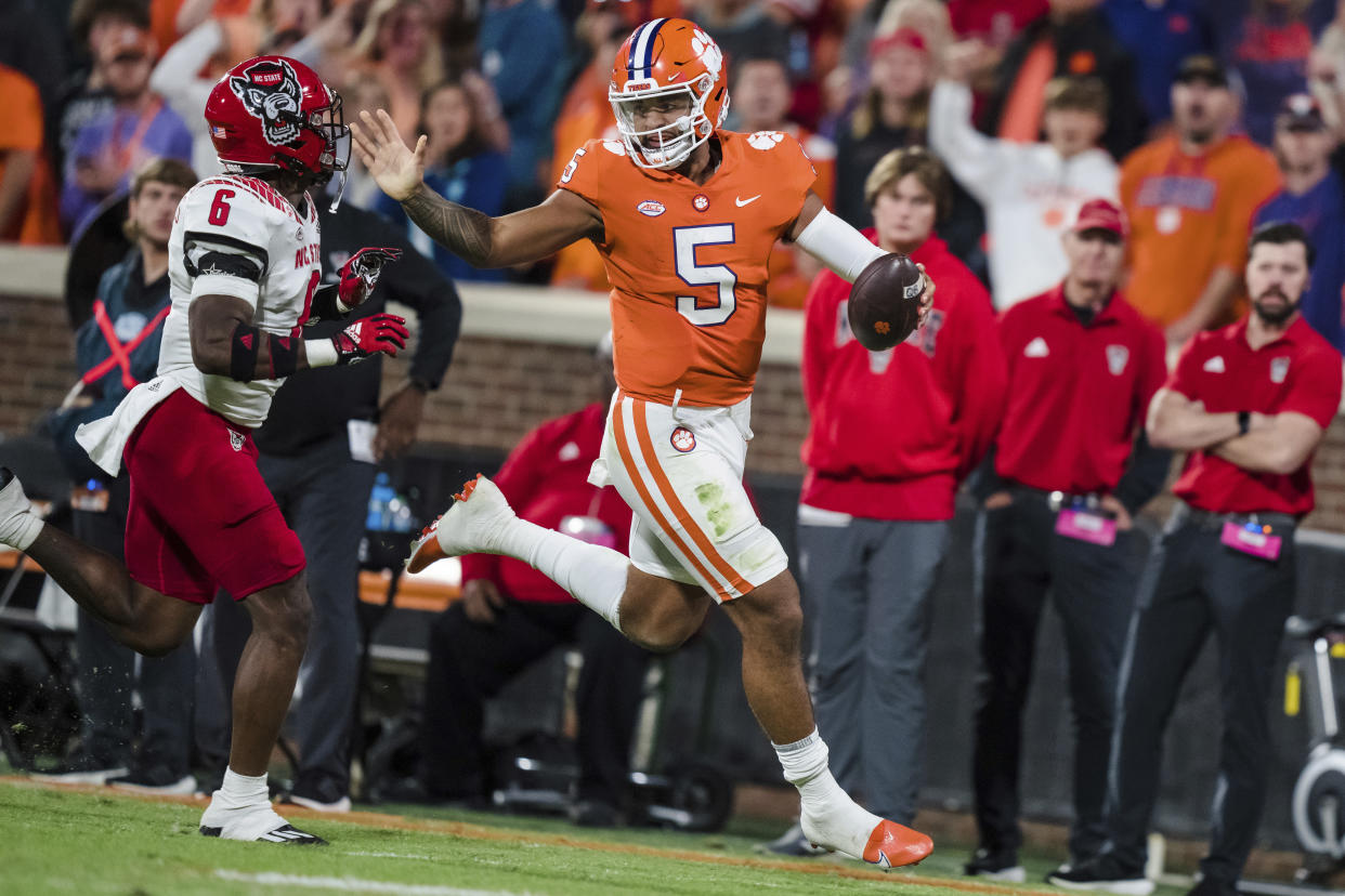 Clemson quarterback DJ Uiagalelei (5) runs with the ball while pursued by North Carolina State safety Jakeen Harris (6) on Saturday, Oct. 1, 2022, in Clemson, S.C. (AP Photo/Jacob Kupferman)